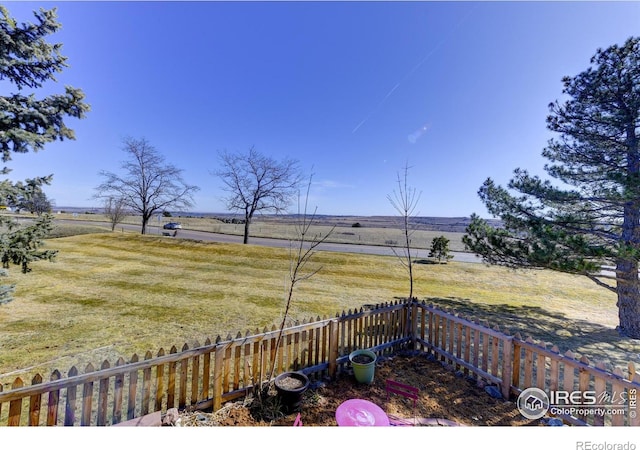 view of yard featuring a rural view and fence