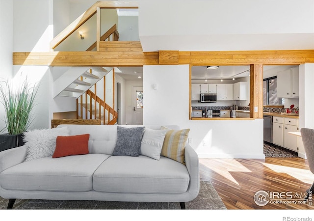 living area with stairway and wood finished floors