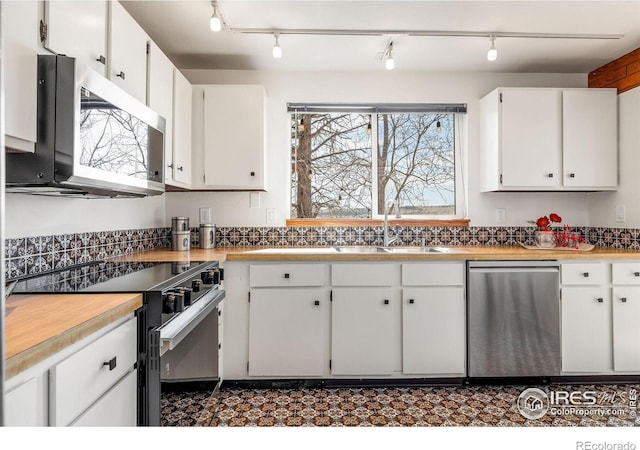 kitchen featuring white cabinets, stainless steel appliances, light countertops, and a sink