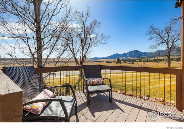 wooden terrace featuring a mountain view and a yard