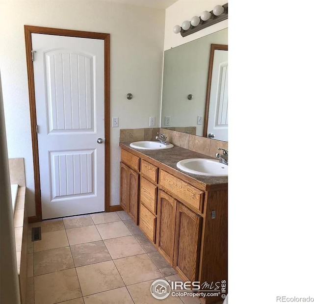 full bath with tile patterned flooring, double vanity, and a sink