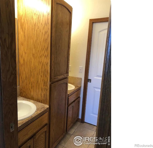 bathroom with tile patterned floors, two vanities, and a sink