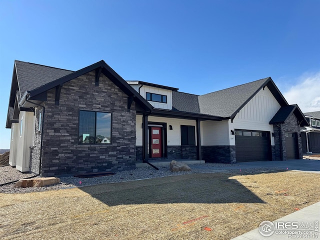 view of front of property featuring stone siding, roof with shingles, and an attached garage