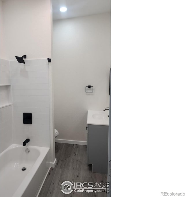 bathroom with vanity, baseboards, shower / tub combination, toilet, and wood finished floors