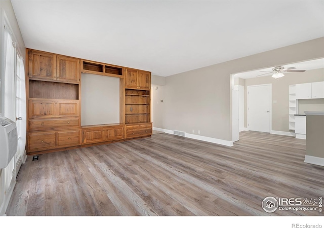 unfurnished living room featuring visible vents, ceiling fan, light wood-type flooring, and baseboards