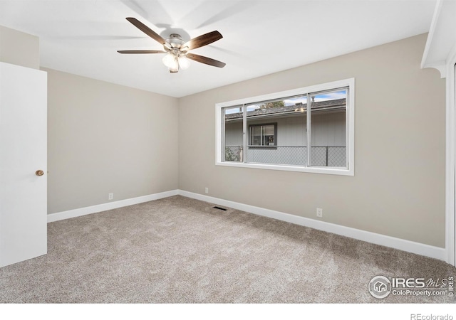 spare room featuring a ceiling fan, baseboards, visible vents, and carpet floors