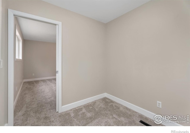 carpeted spare room with baseboards