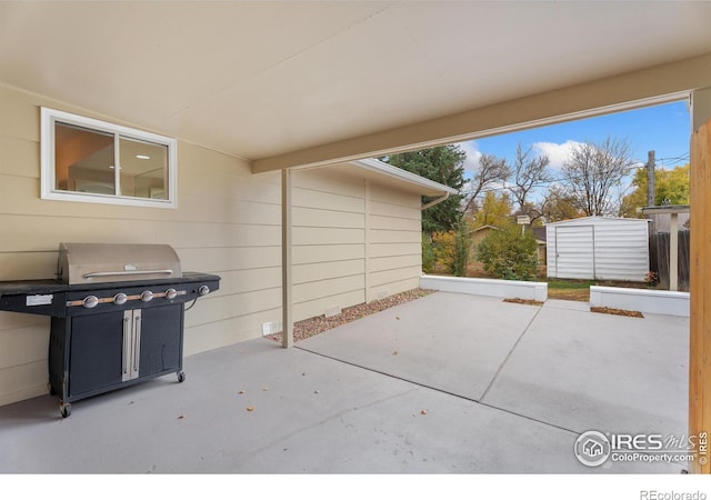 view of patio / terrace featuring an outdoor structure, a storage unit, and a grill