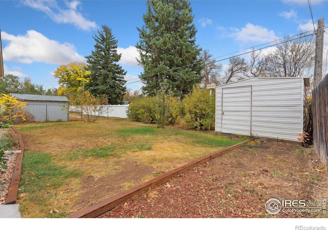 view of yard with a storage shed, a fenced backyard, and an outdoor structure