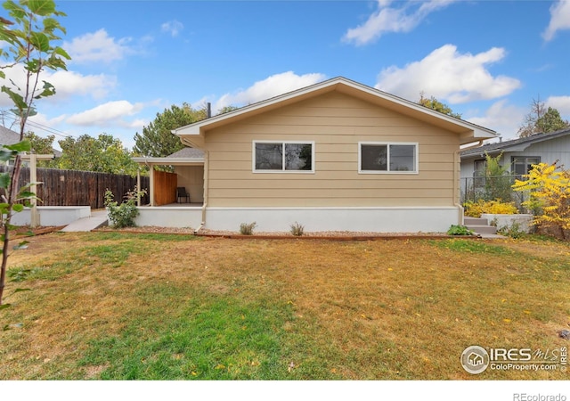 view of front of house with a front yard, fence, and a patio