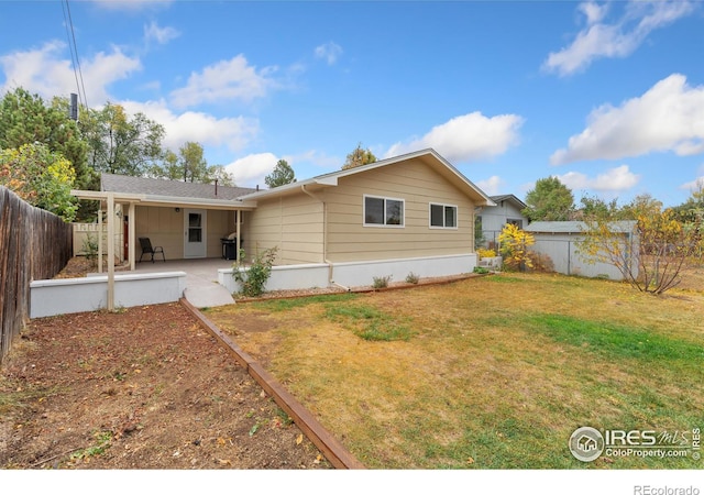 rear view of house featuring a patio area, a lawn, and a fenced backyard