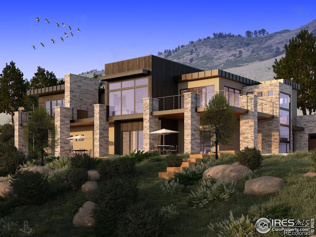 exterior space featuring stone siding and a mountain view