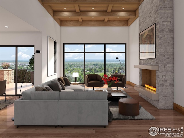 living area with a stone fireplace, beamed ceiling, wood finished floors, and a high ceiling