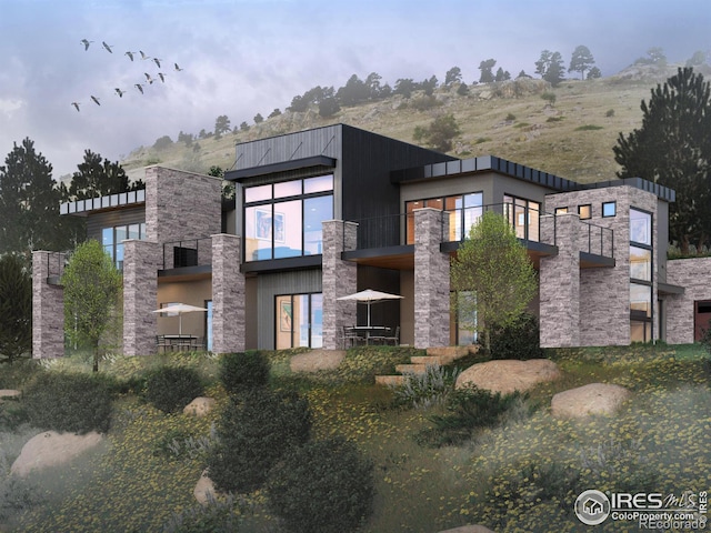 exterior space with stucco siding, stone siding, and a balcony