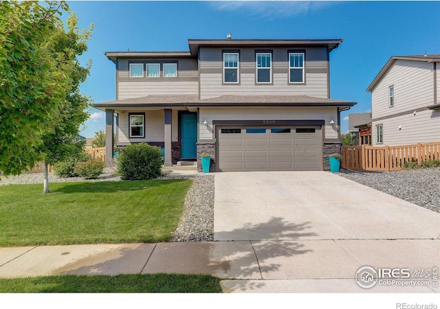 prairie-style house featuring stone siding, fence, concrete driveway, an attached garage, and a front yard