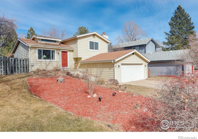 tri-level home with fence, roof with shingles, a chimney, a front lawn, and a garage