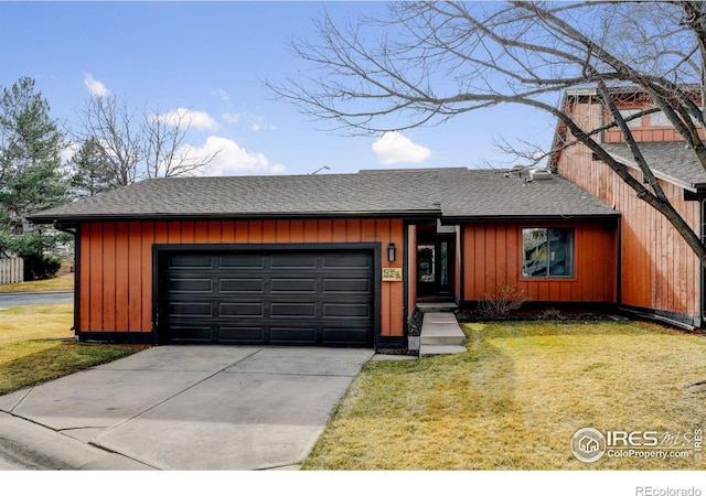 view of front facade with a garage, driveway, roof with shingles, and a front yard