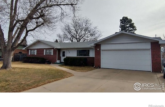 single story home featuring a front yard, brick siding, concrete driveway, and an attached garage