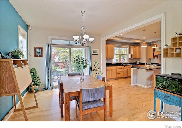 dining space featuring light wood-style floors and a chandelier