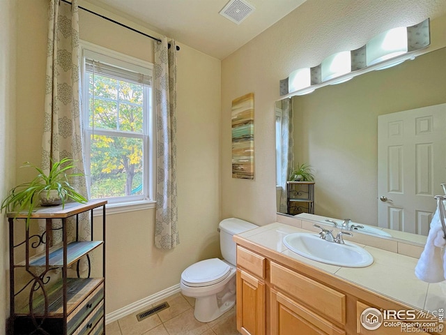 bathroom featuring visible vents, toilet, vanity, and tile patterned flooring