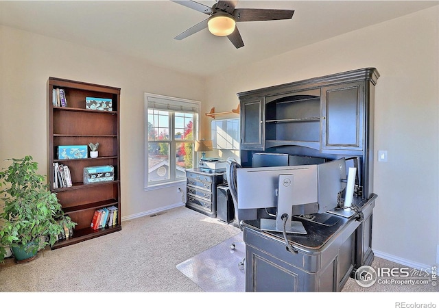 carpeted office featuring visible vents, baseboards, and ceiling fan