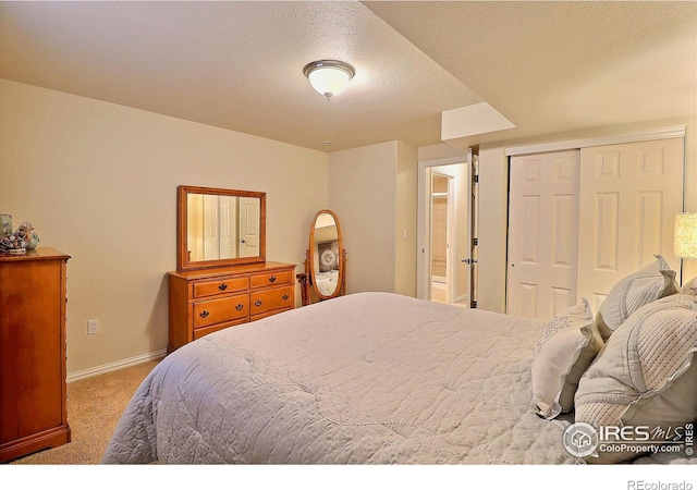 carpeted bedroom featuring a closet, baseboards, and a textured ceiling