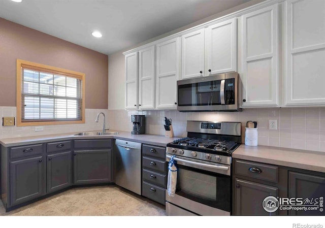 kitchen featuring a sink, tasteful backsplash, appliances with stainless steel finishes, white cabinets, and light countertops