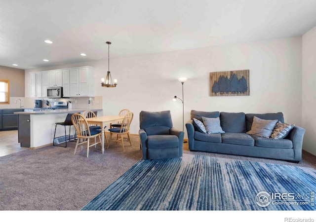 carpeted living room with recessed lighting and an inviting chandelier