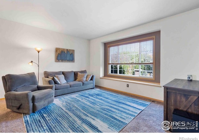 living room featuring visible vents, baseboards, and carpet