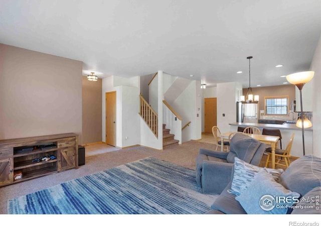 living area featuring a notable chandelier, recessed lighting, baseboards, light colored carpet, and stairs