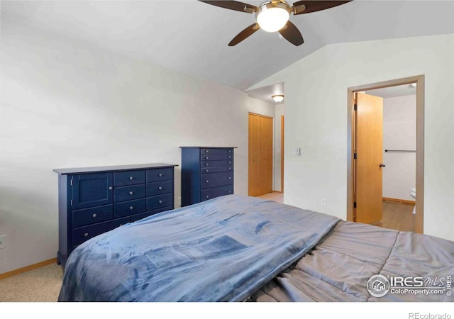 bedroom featuring connected bathroom, a closet, baseboards, ceiling fan, and vaulted ceiling