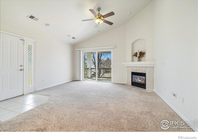 unfurnished living room with a ceiling fan, visible vents, high vaulted ceiling, a tile fireplace, and carpet flooring