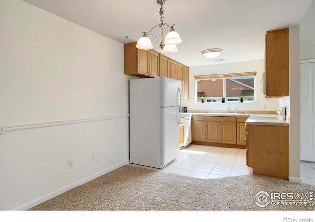 kitchen featuring white appliances, baseboards, light countertops, pendant lighting, and light colored carpet