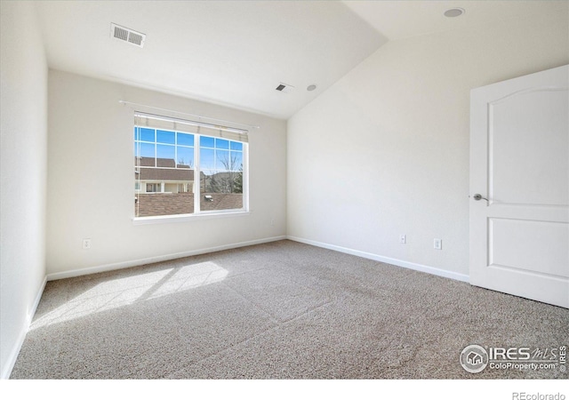 spare room featuring lofted ceiling, baseboards, visible vents, and carpet floors