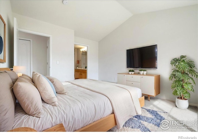 bedroom with vaulted ceiling and connected bathroom