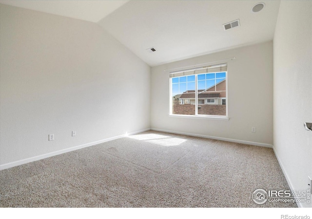 carpeted empty room featuring visible vents, baseboards, and vaulted ceiling