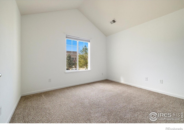 carpeted empty room featuring visible vents, baseboards, and lofted ceiling