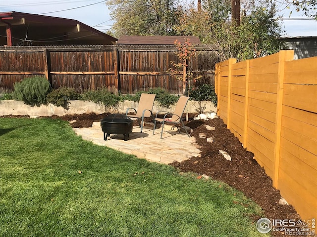 view of yard with a patio area, an outdoor fire pit, and a fenced backyard