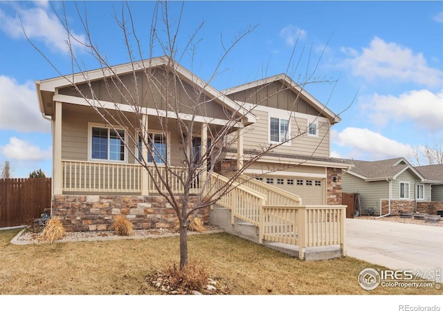 view of front facade featuring covered porch, concrete driveway, an attached garage, and fence