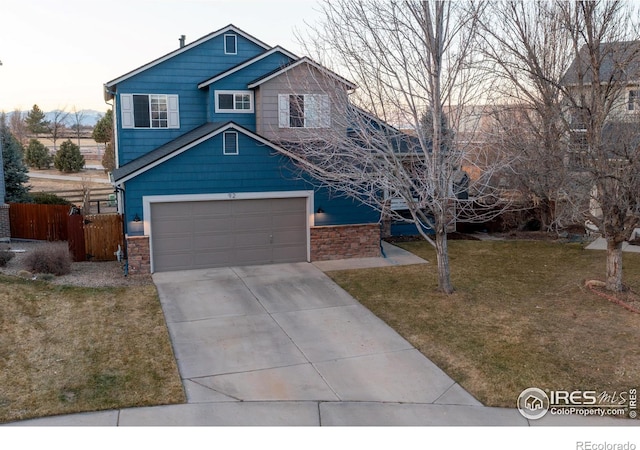 view of front of house featuring an attached garage, concrete driveway, a front lawn, and fence