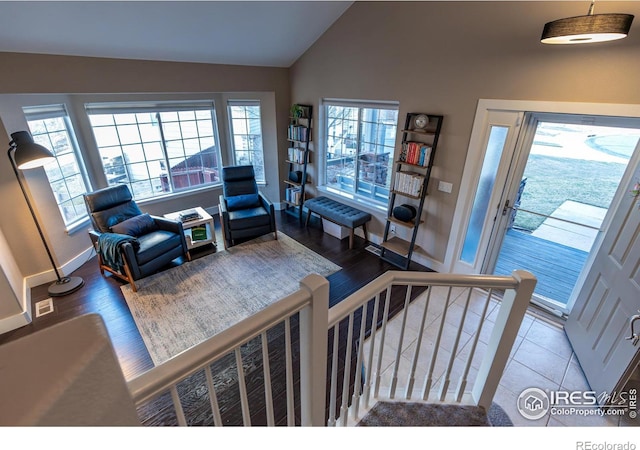 living area with baseboards, stairs, lofted ceiling, and wood finished floors