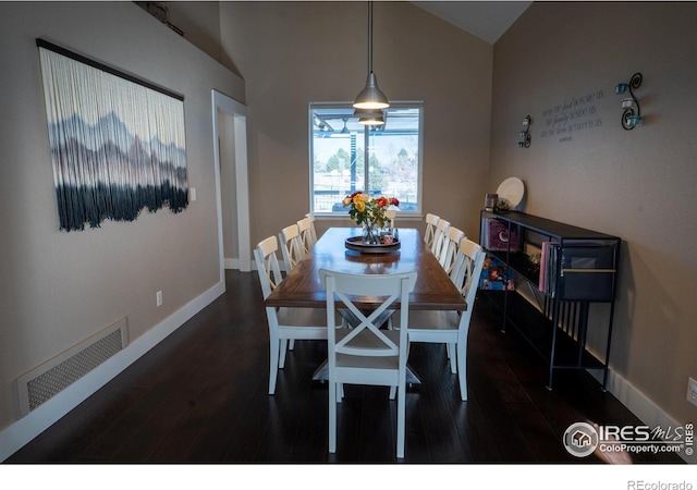 dining area with visible vents, lofted ceiling, baseboards, and wood finished floors