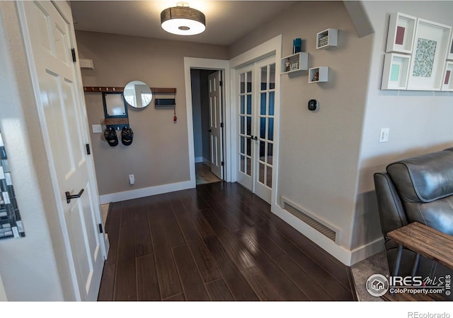 corridor featuring visible vents, french doors, baseboards, and dark wood-style flooring