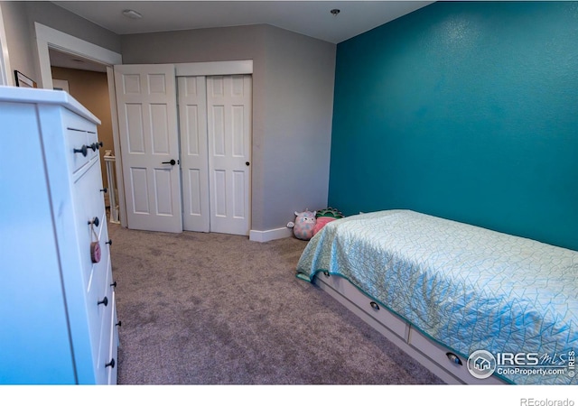 bedroom featuring baseboards, a closet, carpet floors, and lofted ceiling