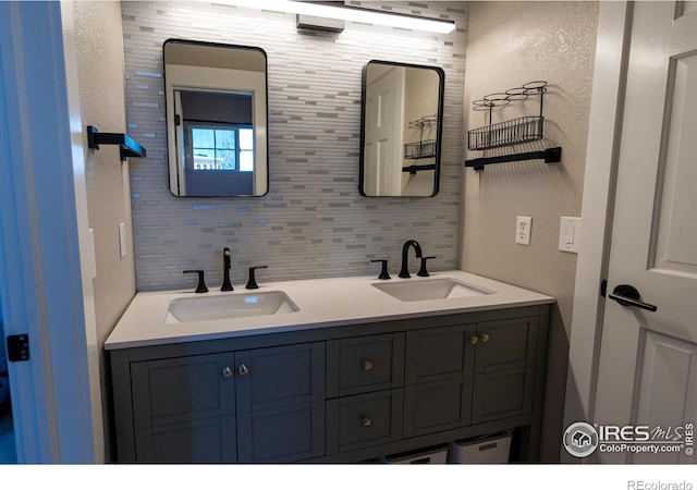 bathroom featuring tasteful backsplash, double vanity, and a sink