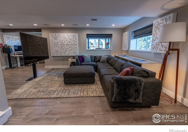 living area featuring visible vents, recessed lighting, baseboards, and wood finished floors