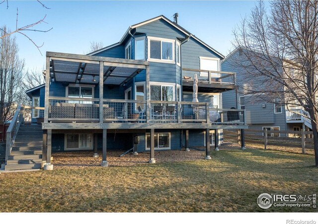 rear view of property with a lawn, stairs, a deck, and fence