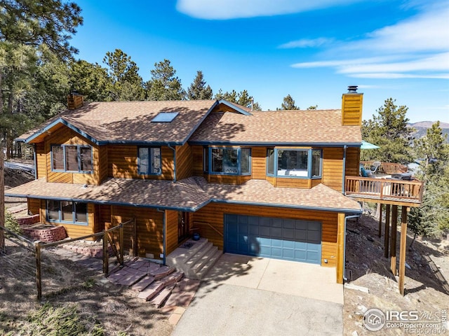 view of front of property with a garage, driveway, a chimney, and roof with shingles