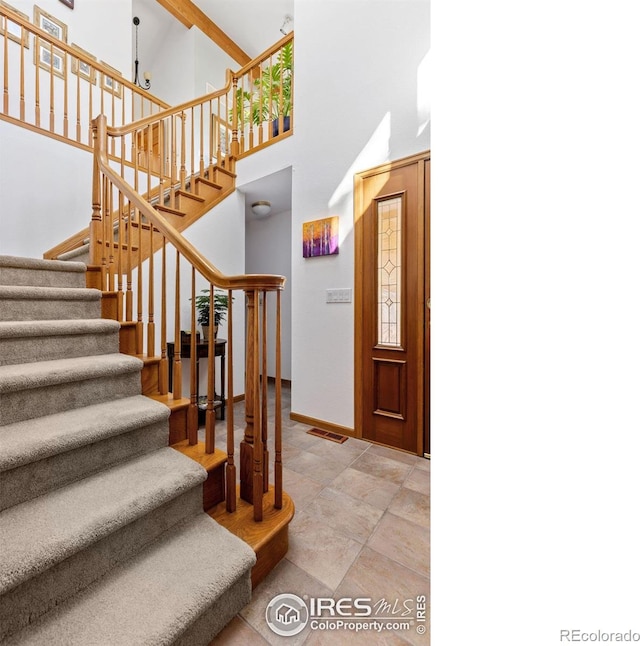 82 Grove Ct, Boulder, CO 80302 - entrance foyer featuring stairway, a high ceiling, baseboards, and light stone finish flooring