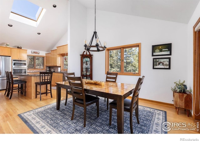 82 Grove Ct, Boulder, CO 80302 - dining area featuring high vaulted ceiling, a skylight, light wood finished floors, a chandelier, and baseboards